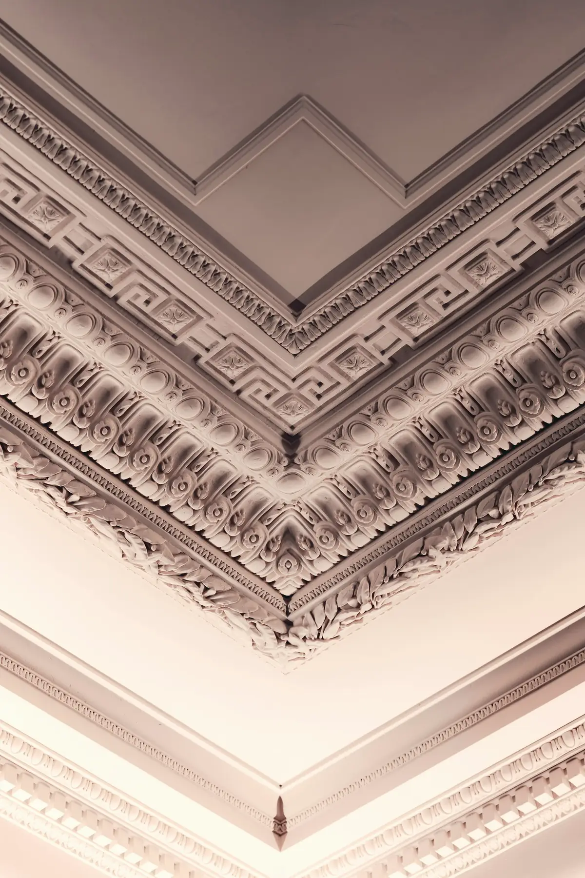 Angle d’un plafond à corniches moulurées, plâtre blanc finement sculpté