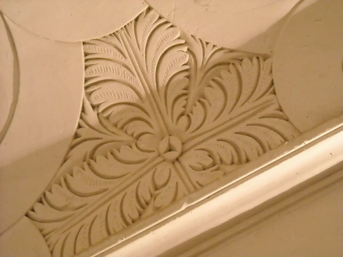 Détail d’une gypserie provençale : feuillages en plâtre sculpté dans une cage d’escalier