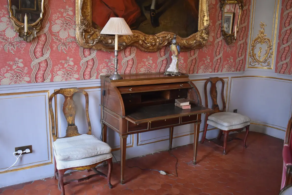 Chambre de l’hôtel de Caumont, à Aix : tomettes au sol, lambris peints et tenture rouge